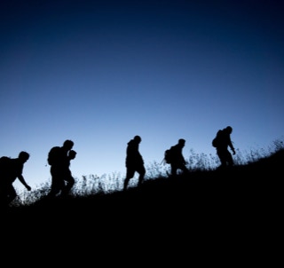 Hikers up a hill with backpacks
